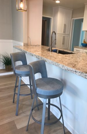 Amisco's Brock Swivel Bar Stools in Silver Metal and Blue Seat/Back Cushion in Kitchen Island with White Cabinets