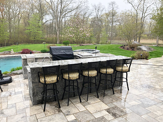 Lisa Furniture's Outdoor Swivel Barstools in Black Metal Finish with Arms and Seat Cushion - Shown Outside Kitchen Grill Area with Pool