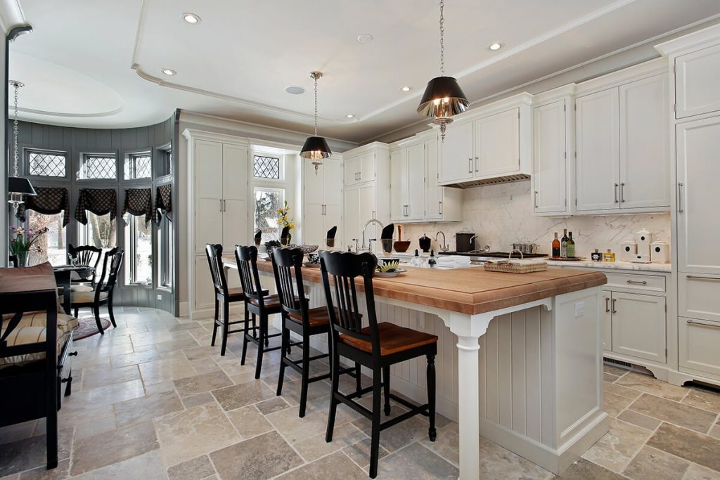 Open concept kitchen dining space with bar stools and dining chairs in the same wood finish
