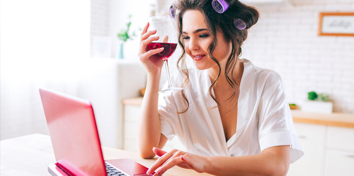 Woman drinking a glass of wine while working