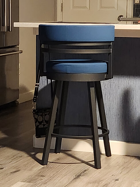 Amisco's Ronny Black Metal Swivel Bar Stool with Blue Seat and Back Cushion in Customer's Kitchen