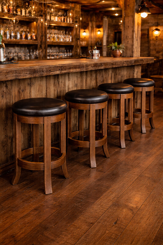 Rustic backless wood swivel bar stools in bar