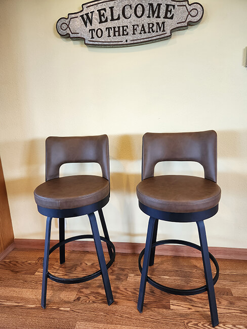 Amisco's Brock Black Low Back Swivel Bar Stools in Brown Vinyl