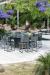 Woodard's Canaveral Harper Woven Outdoor Counter Stools on Patio with Table Near Pool